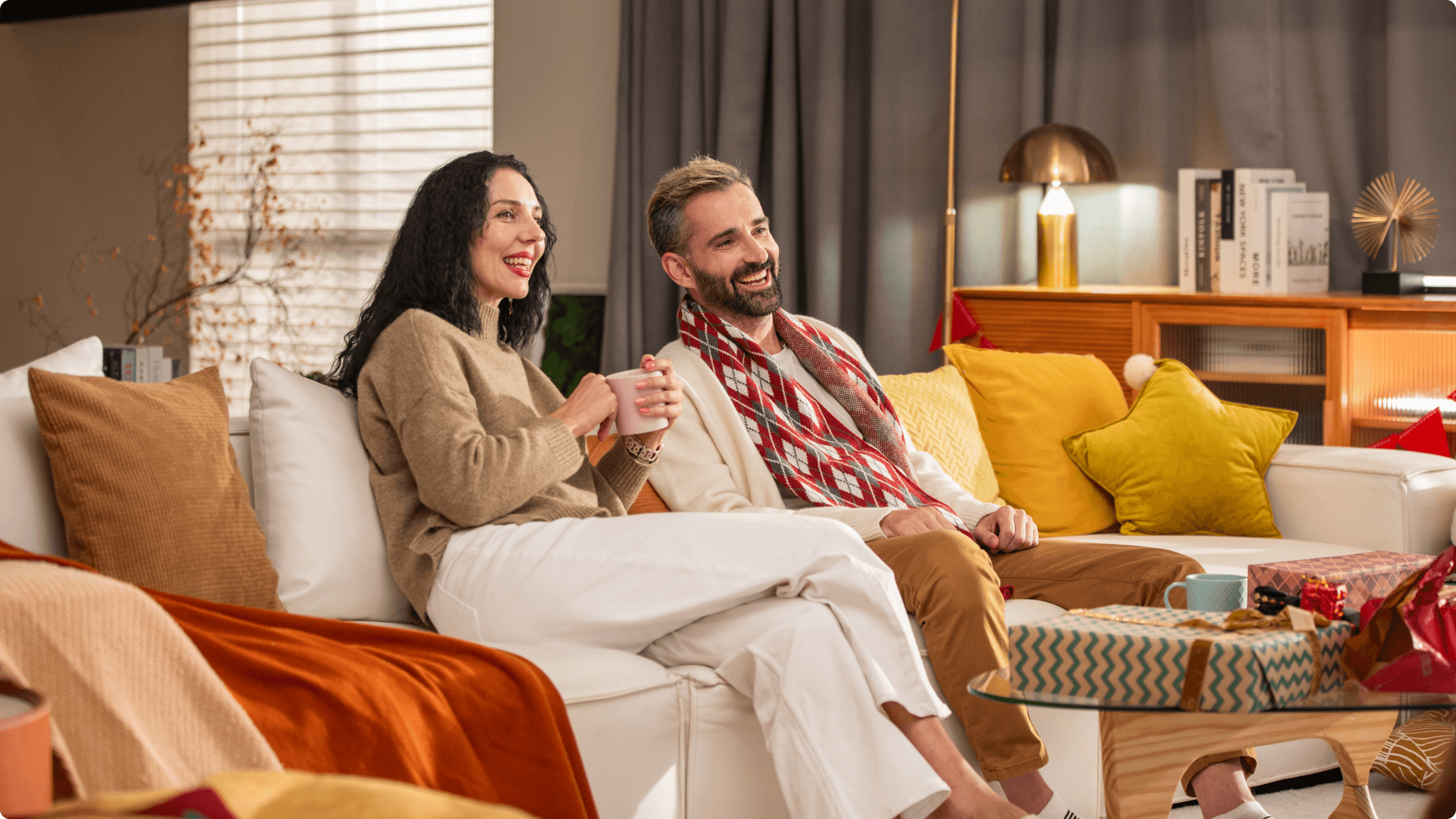 Happy couple sitting on sofa and looking at something