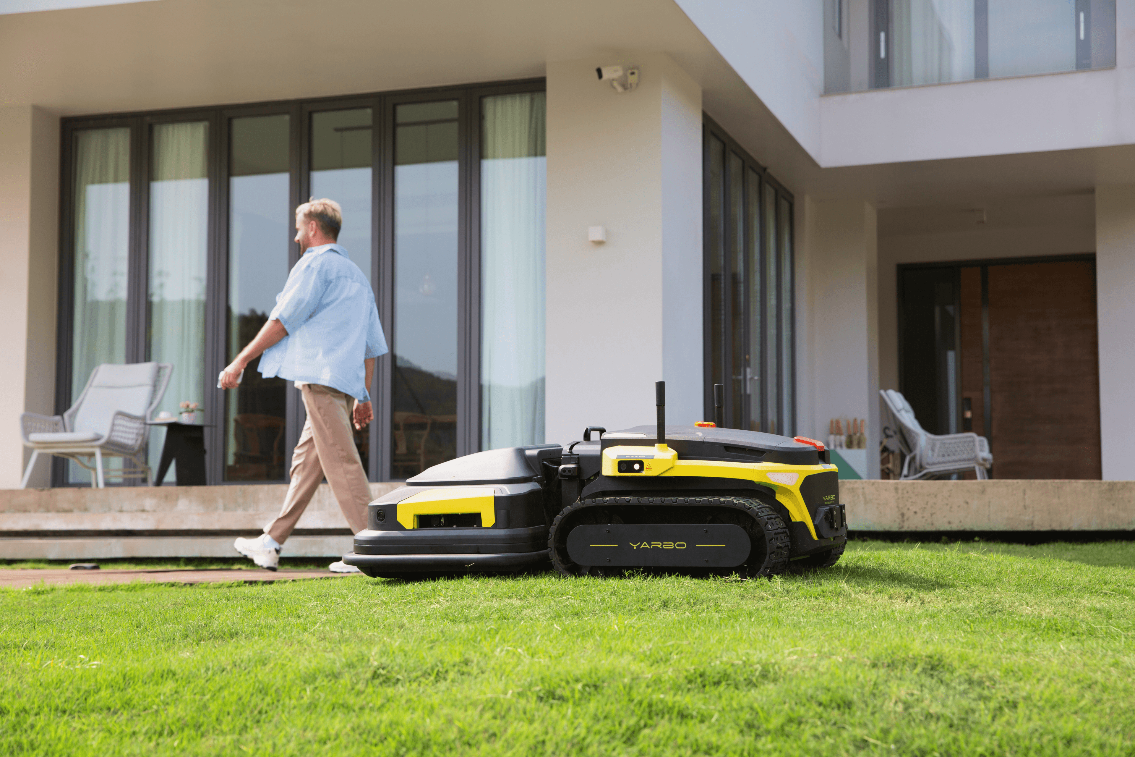 lawn mower robot working on the lawn when a person is going by