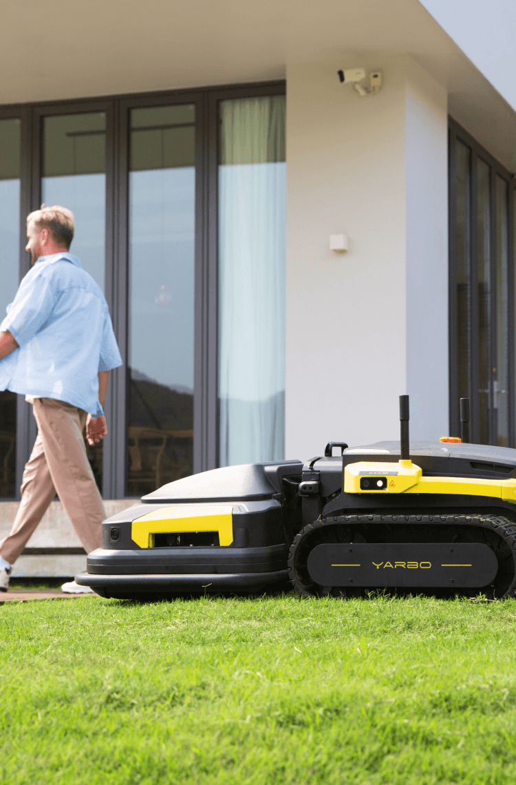 lawn mower robot working on the lawn when a person is going by